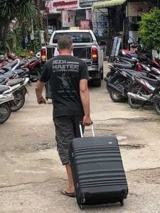man rolling a suitcase thailand 768x1024