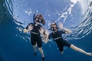 smiling snorkellers on the surface